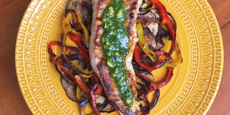 Namorado com pesto de salsinha sobre uma caminha de berinjela e pimentões