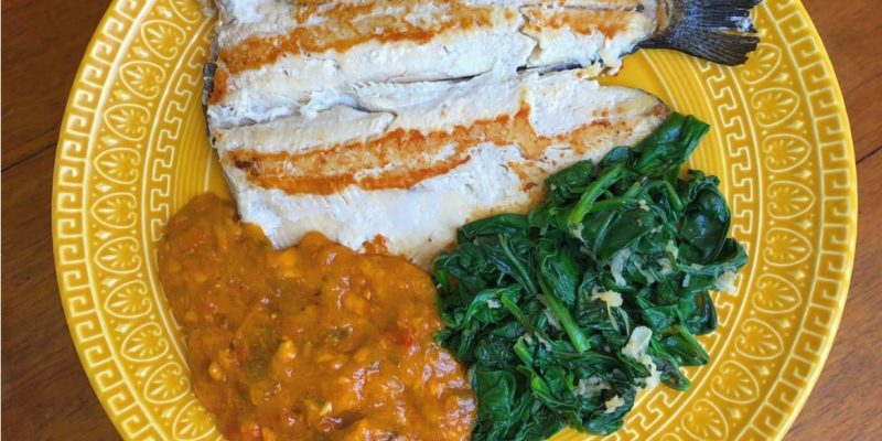 Truta grelhada acompanhada de espinafre com alho e pirão de peixe